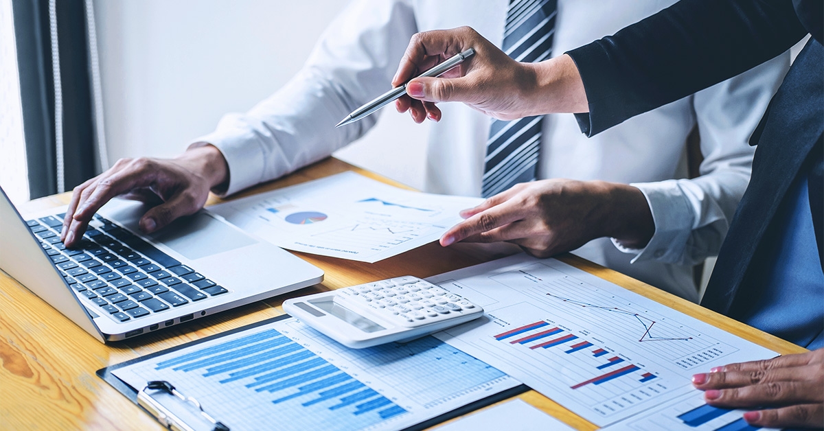 Duas pessoas estudando como reduzir custos logísticos de uma empresa